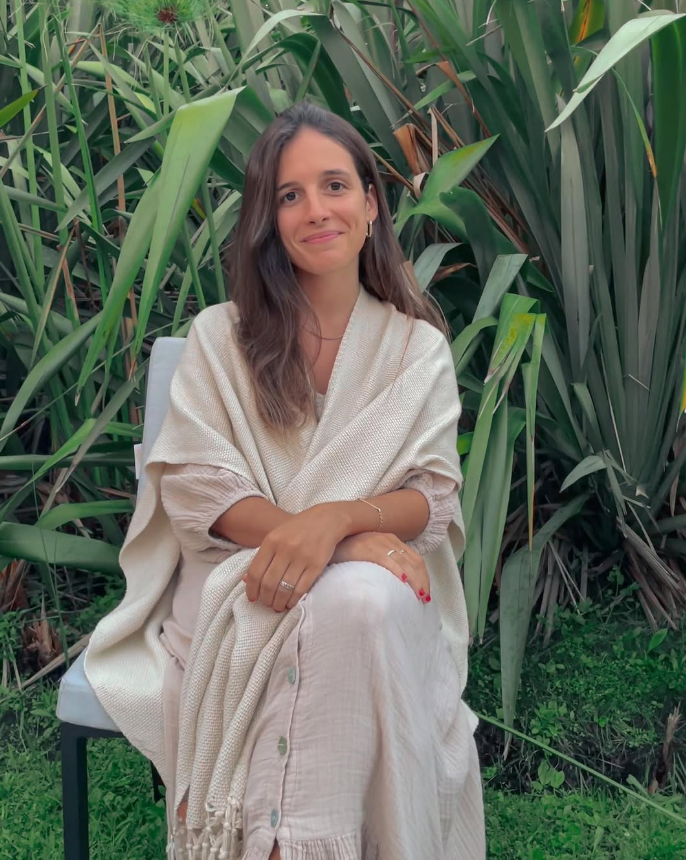 Retrato de Maite, diseñadora de interiores, sentada al aire libre entre vegetación